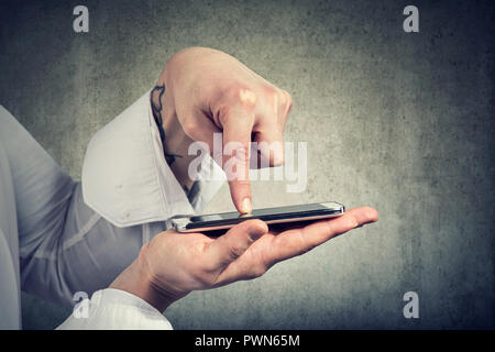 Crop shot of anonymous man in closeup tapping on touchscreen of modern smartphone Stock Photo