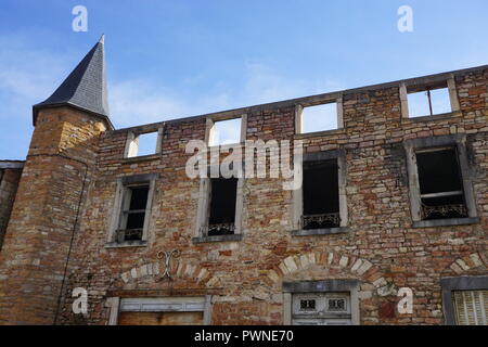 Old colorful stone and brick wall of a facade of a house with a tower and open windows in a town in France Stock Photo