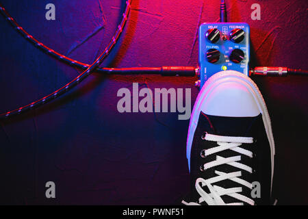 Guitar pedals and footswitch inside recording room. Close up of guitar pedals and musician's foot tapping on it for different sounds. Macro view. Stock Photo