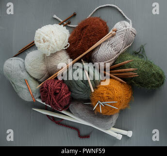 Variety of knitting yarns, hooks and knitting needles on grey background. Top view Stock Photo