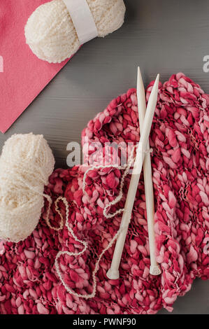 Variety of knitting yarns and knitting needles on grey background. Top view Stock Photo