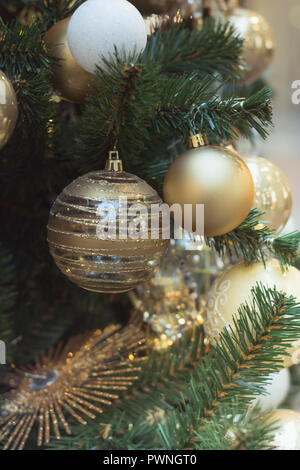 Christmas tree with holiday silver balls and lights with copy space on blurred bokeh in interiors. Close up. Stock Photo