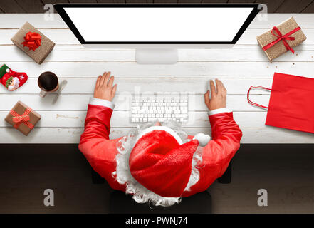 Santa Claus shopping gifts online. The season and discounts. Top view. Stock Photo