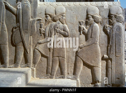 Persepolis. Reliefs on the stairs of the Tripylon, depicting the dignitaries addressing to the party of Nowruz. Detail. Darius I (522-486 BC) and Xerxes I (486-465 BC) period. Islamic Republic of Iran. Stock Photo