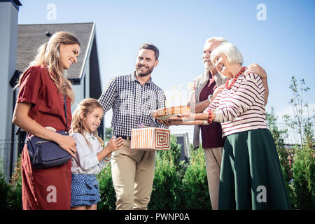 Happy young family visiting their mature relatives Stock Photo
