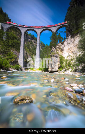 The alpine stream frames the Bernina Express train on Landwasser Viadukt Filisur Albula Valley Canton of Graubünden Switzerland Europe Stock Photo