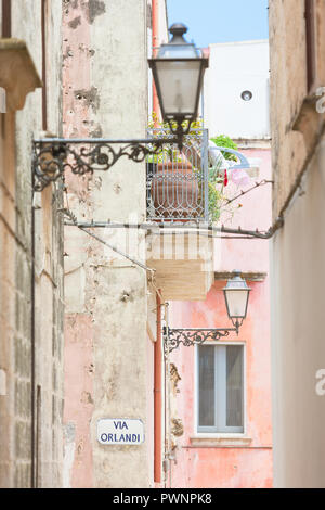 Specchia, Apulia, Italy - Lanterns and a balcony in a historic alleyway