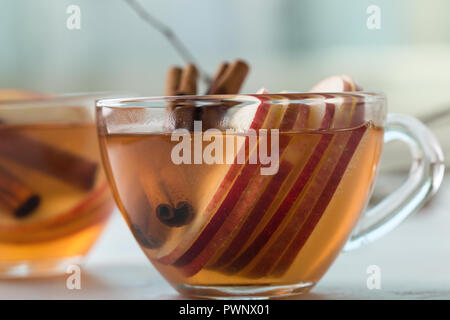 Hot cozy autumn drinks with apple slices on rustic table Stock Photo