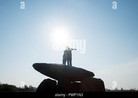 17 October 2018, Saxony-Anhalt, Drosa: 17 October 2018, Germany, Drosa: A father shows his son the surrounding countryside and stands on the big stone tomb Teufelskeller. The ground monument dates back to the Neolithic period. In the morning, the monument information system of Saxony-Anhalt was released on the Internet. The website lists all monuments of the federal state, shows its position on the map and gives basic information about the respective monument. The data had been collected over many years by the State Office for Monument Preservation and Archaeology. Photo: Klaus-Dietmar Gabbert Stock Photo