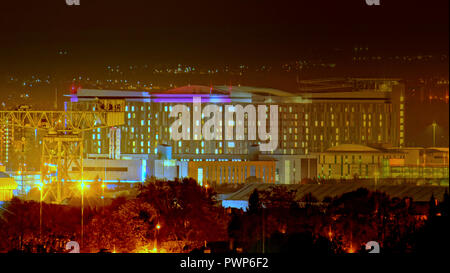 Glasgow, Scotland, UK,17th October, 2018. UK Weather:  Clear skies with a forecast of frost see a cold night in the city. View of the Queen Elizabeth university teaching hospital in Govan isolated by the darkness and lit by colourful electric lights. Gerard Ferry/Alamy news Credit: gerard ferry/Alamy Live News Stock Photo