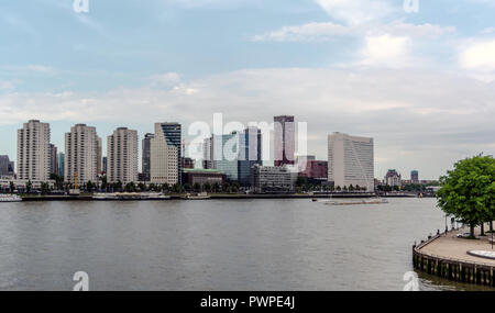 View to the modern innovative city center with tall impressive skyscrapers, and ships on Nieuwe Maas river. Stock Photo