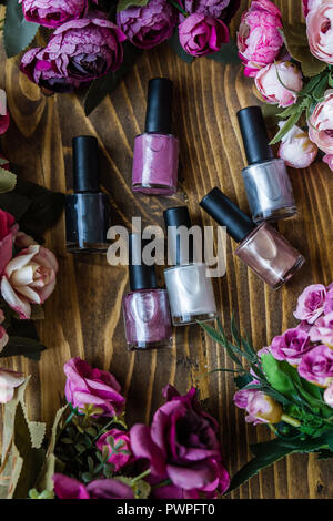 Colorful nail polish bottles on brown wooden background Stock Photo