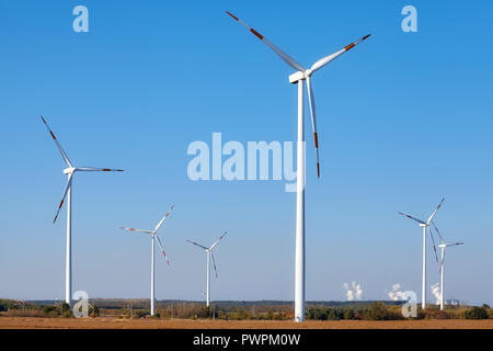 Windmills with smoking chimneys in background. Stock Photo