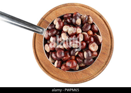 Many chestnuts in frying pan on wooden plate. Isolated on white background. Stock Photo
