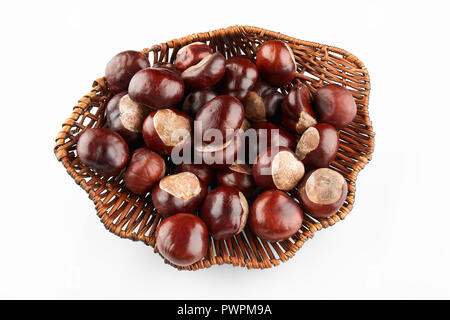 Wicker tray with chestnuts on white background. Stock Photo