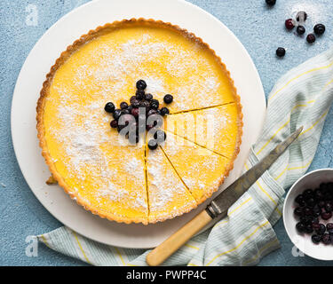 Closeup view of a blueberry and lemon tart with slices cut. Stock Photo