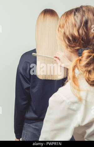 Hairdresser Combs Her Clients Long Blond Hair In Hair Salon Checking The Line Of Haircut Stock Photo Alamy