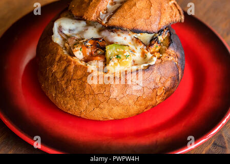 Meat stew served in bread bowl on plate Stock Photo