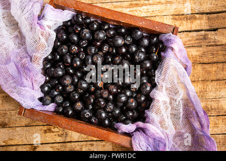 Aronia berries in a wooden box top view, healthy food Stock Photo