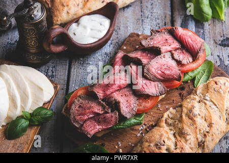 Steak sandwich, sliced roast beef. Home baked bread, mozzarella cheese,spinach leaves,tomato Stock Photo
