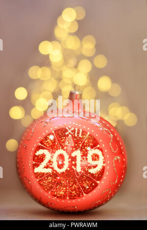 Red glitter ball on grey background. Christmas and new year card. Stock Photo
