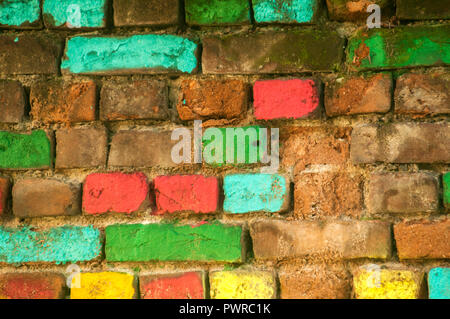 Old weathered grunge house wall with colored bricks in different colors closeup as background Stock Photo