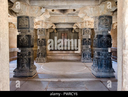 Four intricately carved pillars in Hoysala style inside the main mandapa of Hazara Rama Temple, Hampi, Karnataka, India Stock Photo