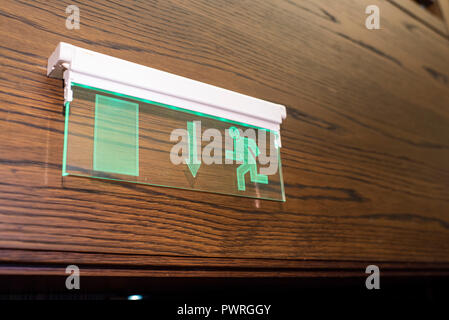 glowing exit sign on the wall Stock Photo