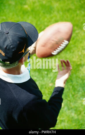 Football Coach with ball on sidelines, USA Stock Photo