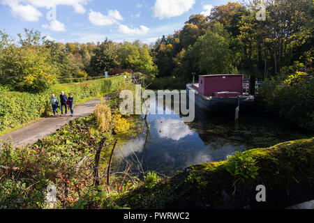 Walking along the Lagan Towpath in Lagan Valley Regional Park past an old canal barge, Belfast, N.Ireland. Stock Photo