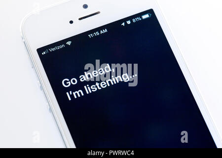 "Go ahead, I'm listening" message by Siri on iPhone screen - USA Stock Photo