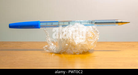 Blue pen on top of a crumpled plastic wrap Stock Photo