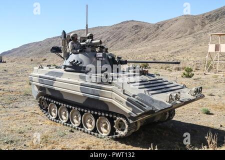 FORT IRWIN, Calif. – Troopers from Coldsteel Troop, 1st Squadron, 11th Armored Cavalry Regiment position their OPFOR Surrogate Vehicle to survey the battlefield from Forward Operating Base “Reno” in the National Training Center, during the 1st Stryker Brigade Combat Team, 4th Infantry Division’s advancement, June 26, 2017. This phase of NTC Rotation 17-07.5 challenged the Raider Brigade’s ability to conduct zone reconnaissance and prepare the area of operations for follow on forces. Stock Photo