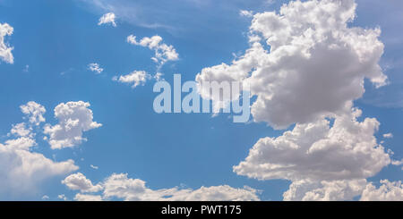 Brilliant blue sky with white puffy clouds Stock Photo