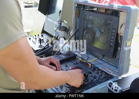 U.S. Soldiers assigned to 705th EOD Company, 63rd EOD Battalion, 52nd EOD Group, 20th CBRNE Command, operates a TALON Robot during Raven’s Challenge 2017 at Camp Shelby, Miss., June 27, 2017. Raven’s Challenge is an annual training event that provides Explosive Ordnance Disposal personnel and Public Safety Bomb Squads of both military and government agencies interoperability in a realistic domestic tactical environment. Stock Photo