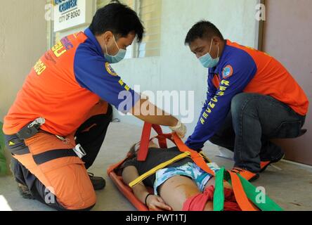 Members of the provincial Disaster Risk Reduction Management Office demonstrate their response capabilities during a mass casualty exercise at Bogo City Hall, Northern Cebu Province, Philippines, June 25, 2017. As part of Pacific Angel 2017, local first responders worked together with U.S. and Philippine forces to share and teach best practices in public health, mass casualty response and other relevant topics. Stock Photo