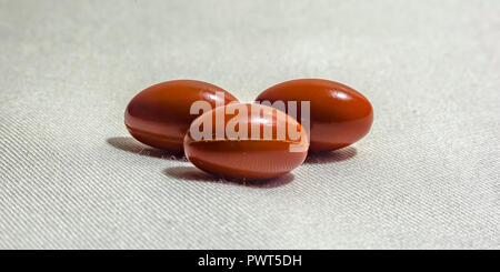 Group of orange pills on fabric textured surface Stock Photo