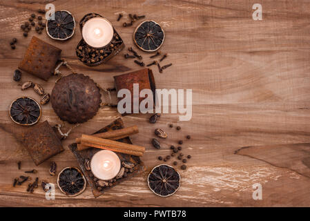 Vintage composition with rusty metal, candles and spices, on wooden background with copy space. Stock Photo
