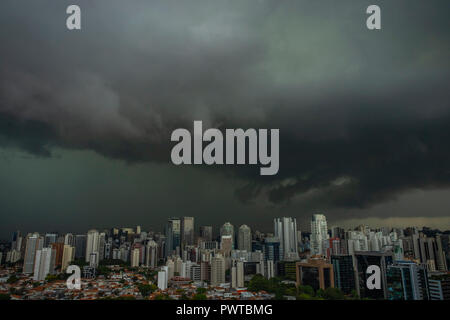 The skyscraper on the background of rainy cloud. It rains very strong in the city. Stock Photo