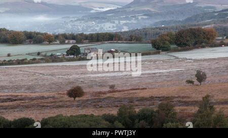 A country pub with Hathersage in the background. Frost is on the ground and mist hangs in the valley. Stock Photo