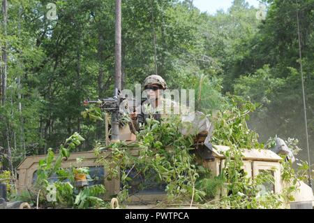 Soldiers of 1st Squadron, 108th Cavalry Regiment, 48th Infantry Brigade Combat Team, 3rd Infantry Division, react to contact while conducting a screen, June 19, 2017 at Fort Stewart, Georgia. The reconnaissance mission was a part of the eXportable Combat Training Capability exercise. Stock Photo