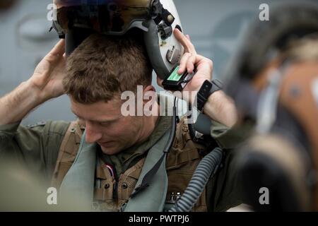 U.S. Marine Corps Capt. Jared G. Cox, a pilot assigned to Marine Fighter Attack Squadron 251, removes a helmet mounted display after a flight during Red Flag-Alaska 17-2 on Joint Base Elmendorf-Richardson, Alaska, June 19, 2017. Red Flag-Alaska provides an optimal training environment in the Indo-Asian Pacific region and focuses on improving ground, space, and cyberspace combat readiness and interoperability for U.S. and international forces. Stock Photo