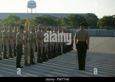 U.S. Marine Corps Staff Sgt. Wesley Paulk, 2nd Recruit Training Battalion drillmaster, watches as Sgt. Cody Waldo gives an order to Platoon 1053, Alpha Company, 1st Recruit Training Battalion, during an initial drill evaluation June 19, 2017, on Parris Island, S.C. Drillmasters, like Paulk, 31, from Baton Rouge, La., evaluate drill instructors, like Waldo, 27, from Wayland, Mich., on their appearance, sword control and their cadence. Alpha Company is scheduled to graduate Aug. 11, 2017. Parris Island has been the site of Marine Corps recruit training since Nov. 1, 1915. Today, approximately 19 Stock Photo