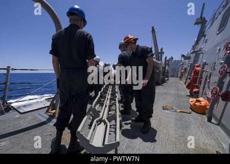 U.S. Sailors load an MK 46 torpedo aboard the guided missile destroyer ...