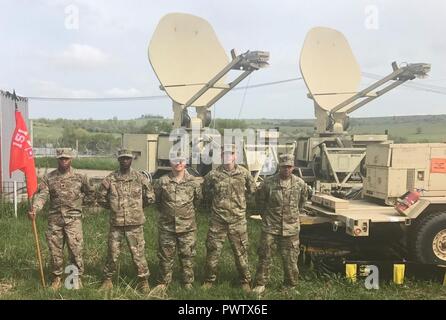 (From left to right: Spc. Jamal Edmonds, 1st Lt. Chippetta Daniels, Staff Sgt. James Blihar , Staff. Sgt. Jerad Kidd and 1st Lt. Quincy Jones)  Soldiers of the 151st Expeditionary Signal Battalion pose for a team photo at the Joint National Training Center, Cincu, Romania, as part of Resolute Castle 2017. This team provided support for internet and phone services to the Joint Operation Center in Cincu, Romania in support of Resolute Castle; the purpose of which is the strengthening of the NATO alliance and enhancement of its capacity for joint training and response to threats within the region Stock Photo