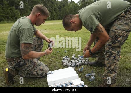 U.S. Marine Corps Sgt. Joshua B. Taylor, left, and Sgt. Dakota Finley, Headquarters Company, Headquarters Regiment, 2nd Marine Logistics Group (MLG) assemble practice grenades during the 2nd MLG Squad Competition at the Battle Skills Training School on Camp Lejeune, N.C., June 21, 2017. 2nd MLG held the competition in order to highlight the outstanding Marines with each battalion, build unit pride and cohesion, and identify common skill deficiencies with the 2nd MLG. Stock Photo