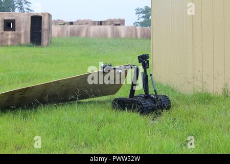 A TALON Robot, controlled by Soldiers assigned to 705th EOD Company, 63rd EOD Battalion, 52nd EOD Group, 20th CBRNE Command, and personnel assigned to Rapides Parish Sheriff’s Office, La., inspects a cabin with explosives during Raven’s Challenge 2017 at Camp Shelby, Miss., June 29, 2017. Raven’s Challenge is an annual training event that provides Explosive Ordnance Disposal personnel and Public Safety Bomb Squads of both military and government agencies interoperability in a realistic domestic tactical environment. Stock Photo