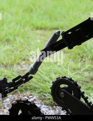 A Mini ANDROS II Robot, controlled by personnel assigned to Rapides Parish Sheriff’s Office, La., passes pieces of a pipe bomb to a TALON Robot controlled by Soldiers assigned to 705th EOD Company, 63rd EOD Battalion, 52nd EOD Group, 20th CBRNE Command, during Raven’s Challenge 2017 at Camp Shelby, Miss., June 29, 2017. Raven’s Challenge is an annual training event that provides Explosive Ordnance Disposal personnel and Public Safety Bomb Squads of both military and government agencies interoperability in a realistic domestic tactical environment. Stock Photo