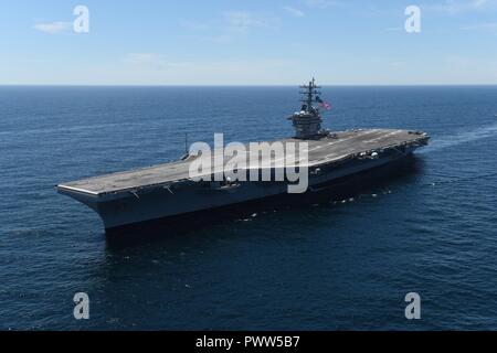 ATLANTIC OCEAN (June 27, 2017) The aircraft carrier USS Dwight D. Eisenhower (CVN 69) flies the national ensign at half-mast in honor of the seven Sailors who lost their lives aboard the Arleigh Burke-class guided-missile destroyer USS Fitzgerald (DDG 62). Dwight D. Eisenhower is underway conducting a bilateral group sail with the Canada 150 anniversary celebration. ( Stock Photo