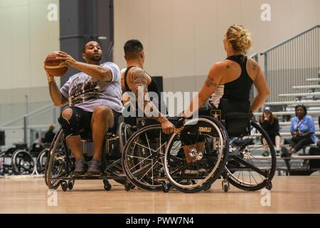 U.S. Army Sgt. Christopher McGinnis, from Bethesda, Md., practices for the wheelchair basketball competition for the 2017 Department of Defense Warrior Games at Chicago, Ill., June 29, 2017. The DOD Warrior Games are an annual event allowing wounded, ill and injured service members and veterans in Paralympic-style sports including archery, cycling, field, shooting, sitting volleyball, swimming, track and wheelchair basketball. Stock Photo